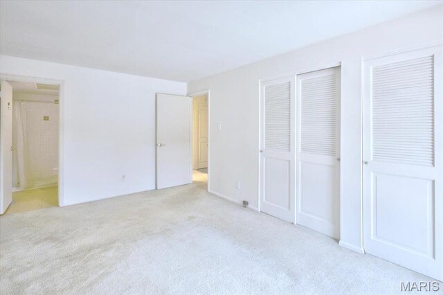 13515 Coliseum Dr Unit A, Chesterfield, MO 63017 - unfurnished bedroom featuring light carpet, two closets, and ensuite bath