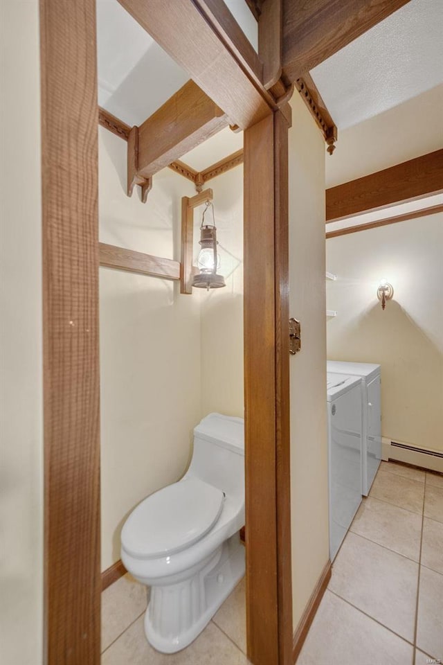 12044 State Route A, Saint Genevieve, MO 63670 - bathroom featuring washer and dryer, tile patterned floors, a baseboard heating unit, toilet, and baseboards