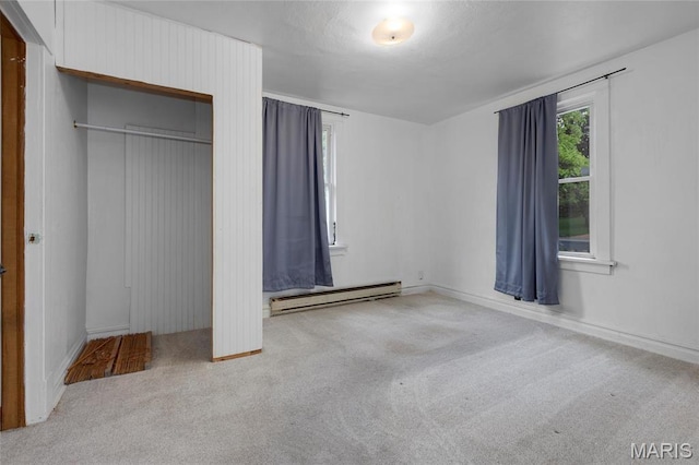 unfurnished bedroom featuring a baseboard radiator, carpet, a closet, and baseboards