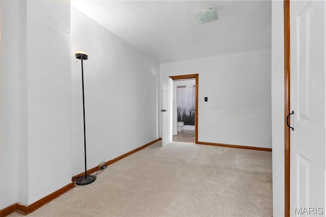 carpeted empty room featuring baseboards