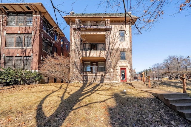 rear view of house with a balcony and brick siding