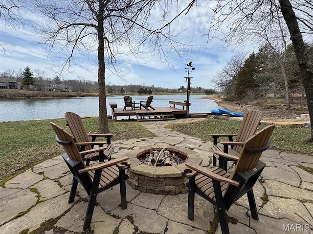 view of patio with an outdoor fire pit and a water view
