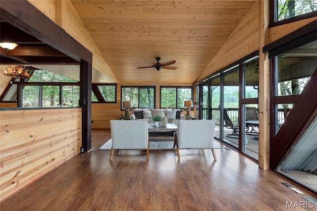 sunroom with vaulted ceiling, ceiling fan, wooden ceiling, wood walls, and wood finished floors