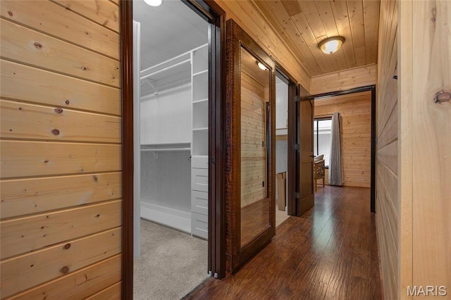 hall with wood walls, wood ceiling, and dark wood-style floors