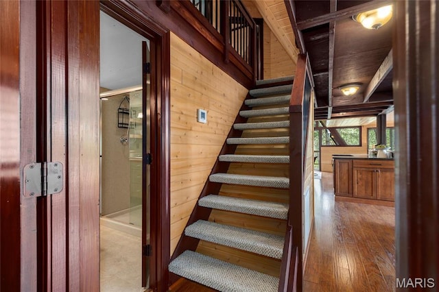 staircase featuring wood walls and wood finished floors