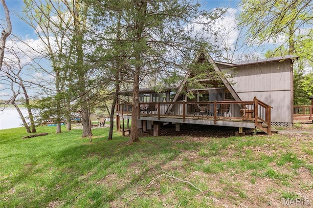 rear view of house featuring a deck and a yard