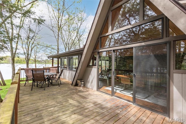 deck featuring outdoor dining area and a water view