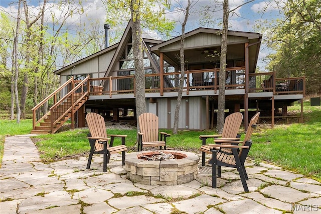view of patio / terrace with a fire pit, a wooden deck, stairs, and a ceiling fan