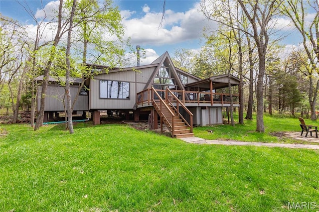 back of property featuring a wooden deck, stairway, and a lawn