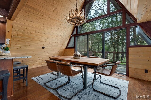 803 S Aspen Point Dr, Innsbrook, MO 63390 - dining space with wooden walls, a chandelier, lofted ceiling, and wood finished floors