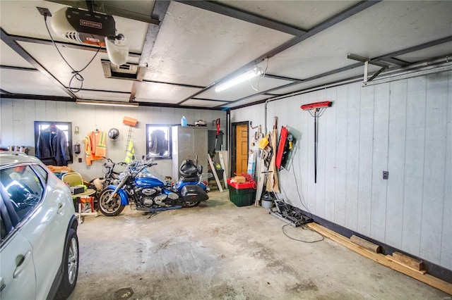 239 Olive St, Rockbridge, IL 62081 - garage featuring a garage door opener and wooden walls