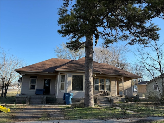 bungalow-style home featuring covered porch and a shingled roof