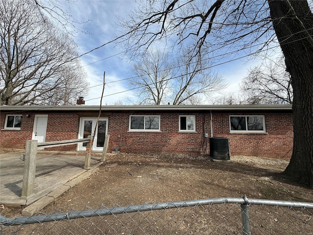 1227 Teson Rd, Hazelwood, MO 63042 - view of front of house with brick siding, fence, central AC unit, and a chimney