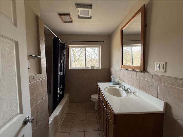 1227 Teson Rd, Hazelwood, MO 63042 - full bath with tile walls, tile patterned floors, toilet, vanity, and a wainscoted wall