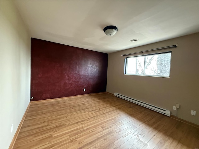 1227 Teson Rd, Hazelwood, MO 63042 - unfurnished room with a baseboard heating unit, light wood finished floors, baseboards, and an accent wall