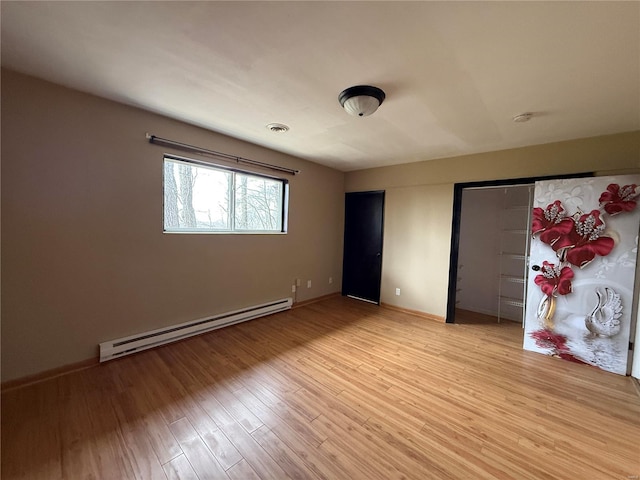 1227 Teson Rd, Hazelwood, MO 63042 - unfurnished bedroom featuring a baseboard radiator, light wood-type flooring, and baseboards