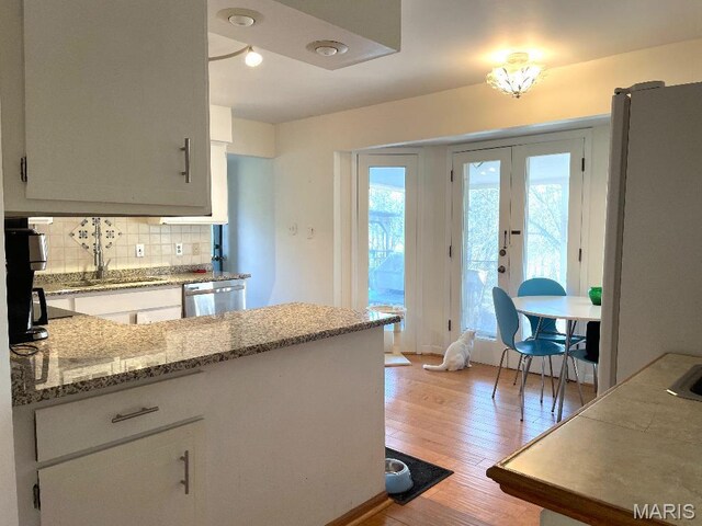 3921 Allenton Rd, Wildwood, MO 63069 - kitchen with stainless steel dishwasher, light wood finished floors, backsplash, light stone counters, and french doors
