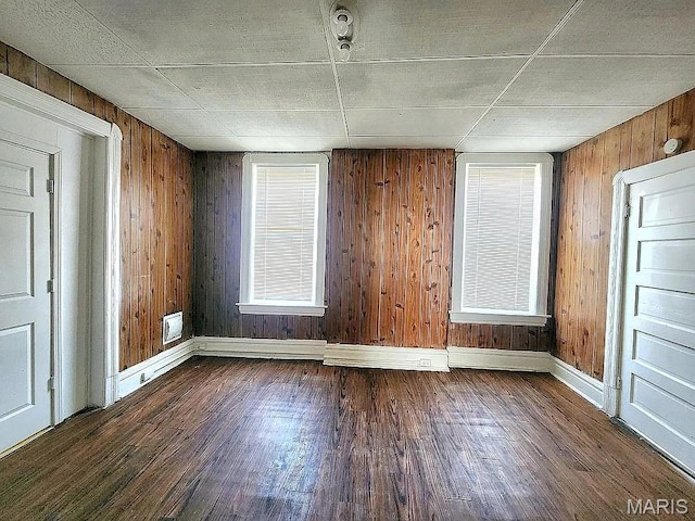 5244 Theodosia Ave, Saint Louis, MO 63113 - spare room featuring dark wood-style floors, baseboards, wood walls, and plenty of natural light