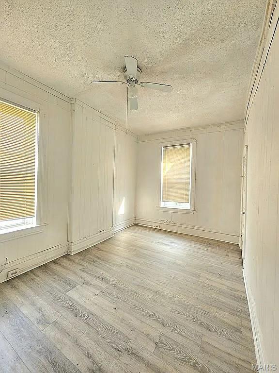 5244 Theodosia Ave, Saint Louis, MO 63113 - spare room with light wood-style floors, a textured ceiling, plenty of natural light, and ceiling fan