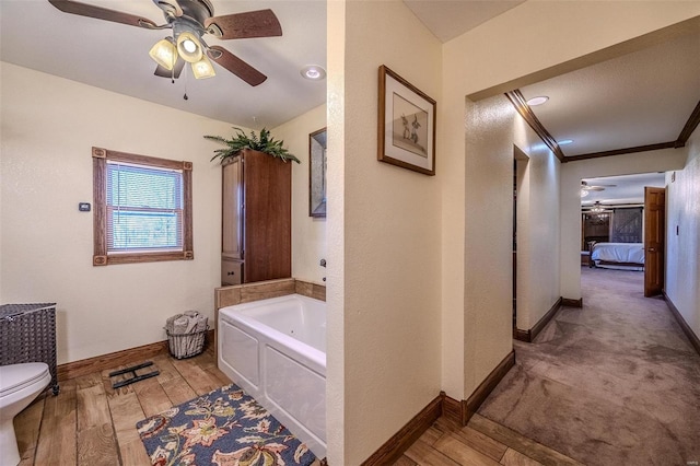 20677 Bend Rd, Crocker, MO 65452 - ensuite bathroom featuring a ceiling fan, toilet, a bath, baseboards, and crown molding