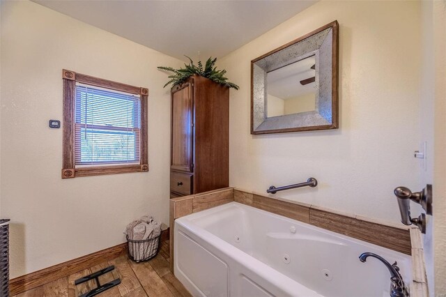 20677 Bend Rd, Crocker, MO 65452 - full bathroom featuring a tub with jets and wood finished floors