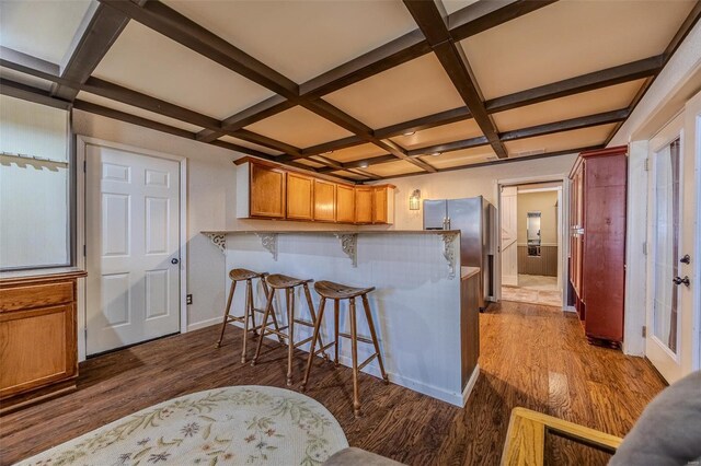 20677 Bend Rd, Crocker, MO 65452 - kitchen with coffered ceiling, dark wood-style flooring, a breakfast bar, freestanding refrigerator, and a peninsula