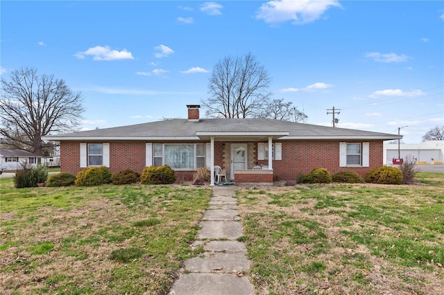 ranch-style house featuring brick siding, a chimney, and a front yard