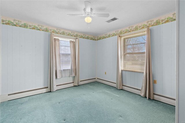 carpeted empty room with a ceiling fan