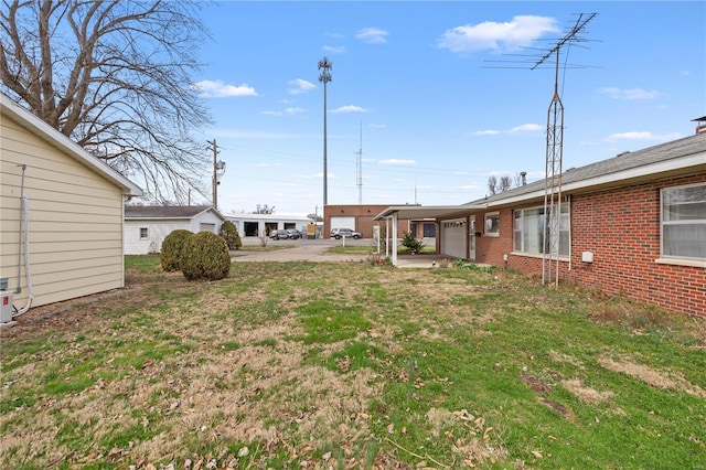 view of grassy yard with an attached garage and driveway