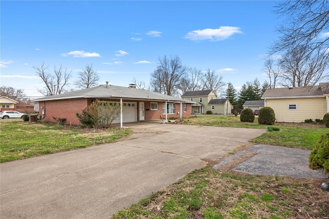view of front of home with a garage, driveway, a front lawn, and brick siding