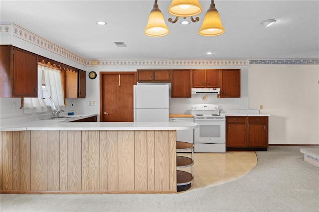 kitchen featuring white appliances, under cabinet range hood, a peninsula, light countertops, and recessed lighting