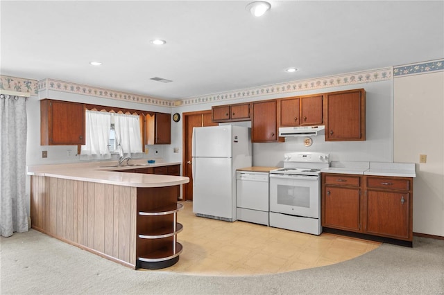 kitchen with white appliances, under cabinet range hood, light countertops, a peninsula, and a sink