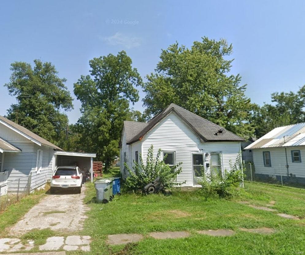 view of home's exterior featuring driveway, a lawn, and a carport