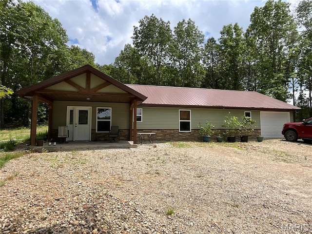 2887 County Road 5620, Willow Springs, MO 65789 - rear view of property featuring metal roof, stone siding, a porch, and a garage