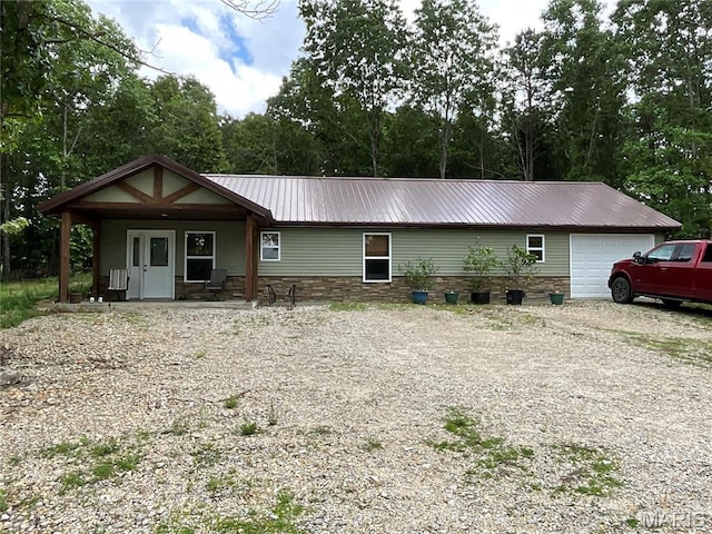 2887 County Road 5620, Willow Springs, MO 65789 - view of front of property with metal roof, an attached garage, covered porch, driveway, and stone siding