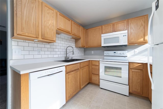 kitchen featuring white appliances, a sink, light countertops, and backsplash