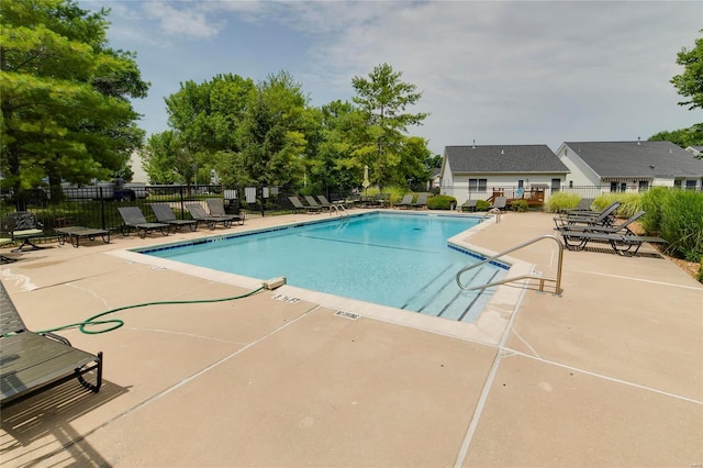 community pool with a patio and fence