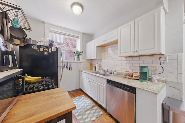 5044 Lindenwood Ave, Saint Louis, MO 63109 - kitchen with appliances with stainless steel finishes, a sink, white cabinets, and light wood-style flooring