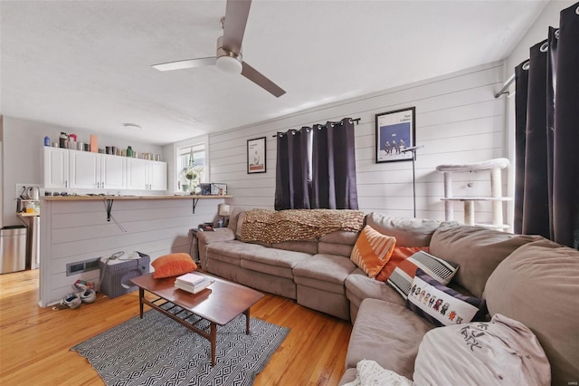5044 Lindenwood Ave, Saint Louis, MO 63109 - living room with wooden walls, light wood-type flooring, and a ceiling fan