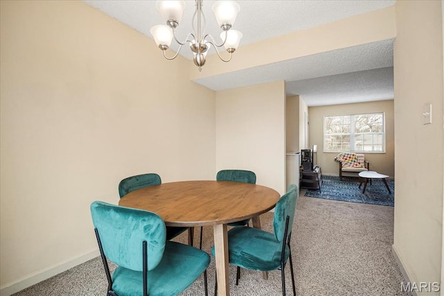 dining room with carpet, a chandelier, baseboards, and a textured ceiling