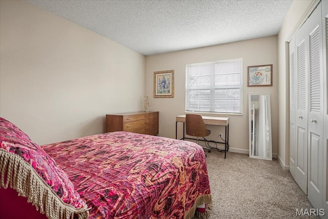 carpeted bedroom with a closet and a textured ceiling