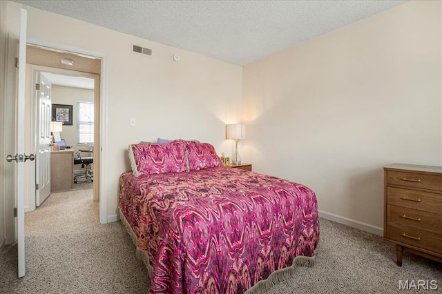 carpeted bedroom featuring a textured ceiling and baseboards