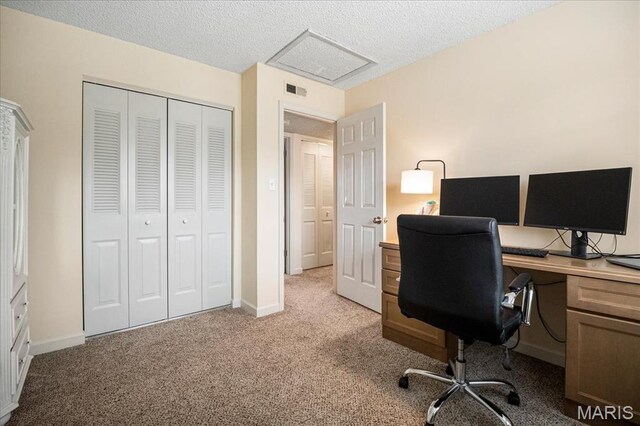 office featuring light carpet, a textured ceiling, attic access, and baseboards