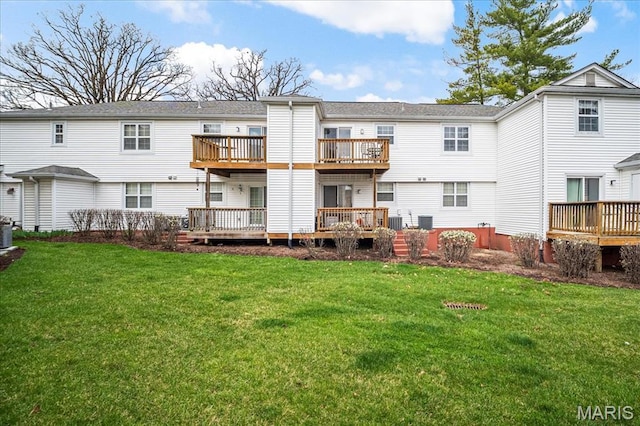 back of property featuring a deck and a lawn