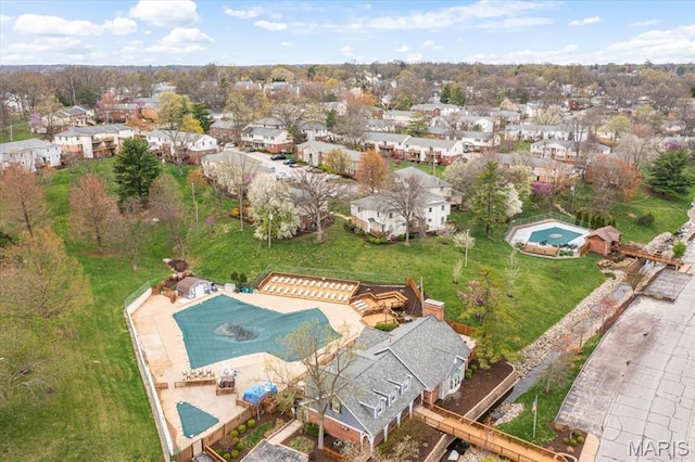 aerial view of property's location with a pool and nearby suburban area