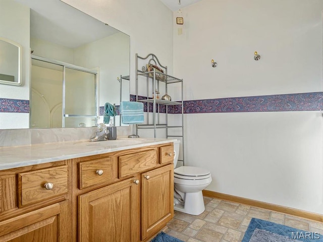 100 Fairway Dr, Waterloo, IL 62298 - bathroom featuring vanity, a stall shower, toilet, stone finish flooring, and baseboards