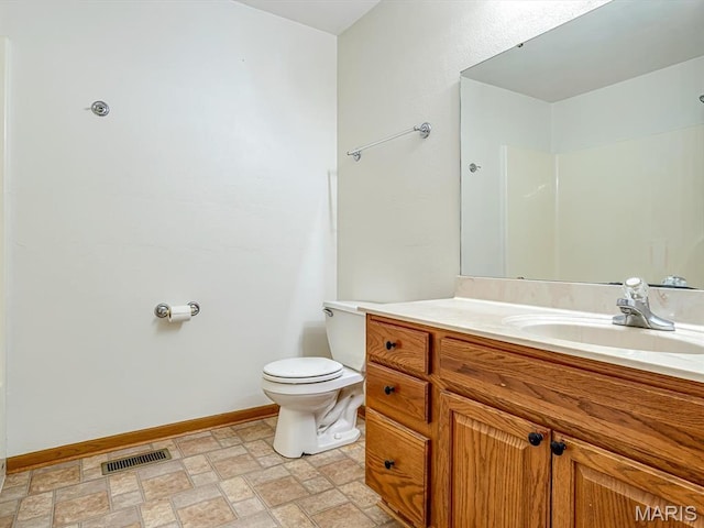 100 Fairway Dr, Waterloo, IL 62298 - bathroom with toilet, vanity, stone finish floors, and baseboards