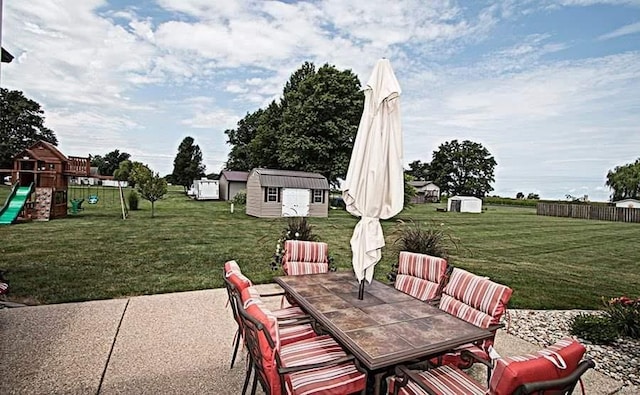 15919 Candy Corner Ln, Carlyle, IL 62231 - view of patio featuring outdoor dining space, an outdoor structure, a storage shed, and a playground