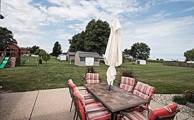 15919 Candy Corner Ln, Carlyle, IL 62231 - view of patio with outdoor dining area, a storage shed, and a playground