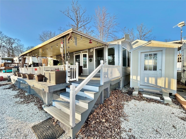 view of front of property featuring an outbuilding, a shed, and a wooden deck